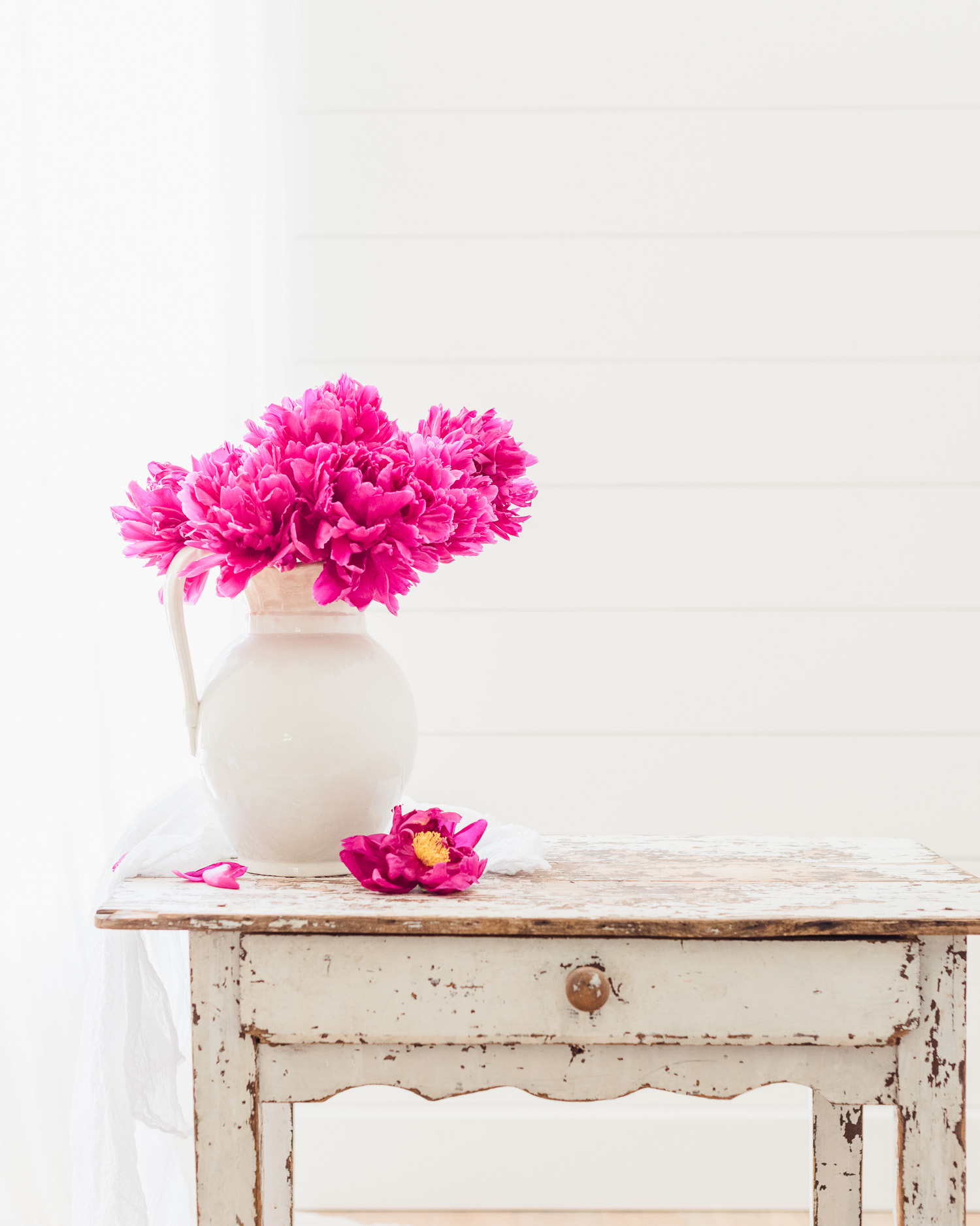 Pink Peonies in a ironstone vase on a desk