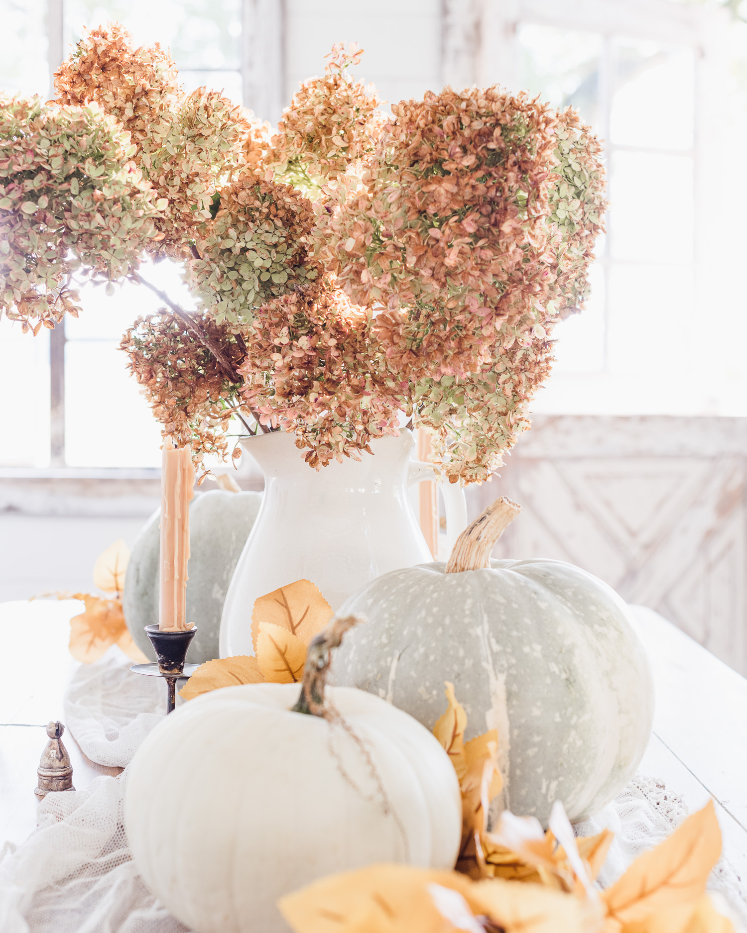 Dried hydrangeas in an ironstone vase & pumpkins for a fall tablescape