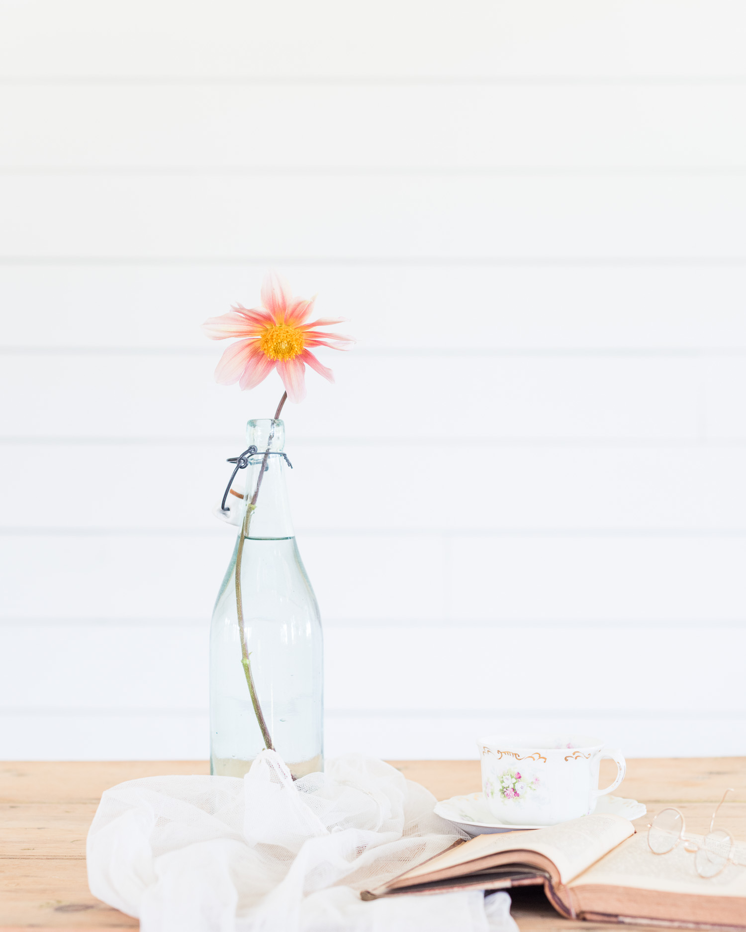 Vintage bottle with one flower, voile, & book