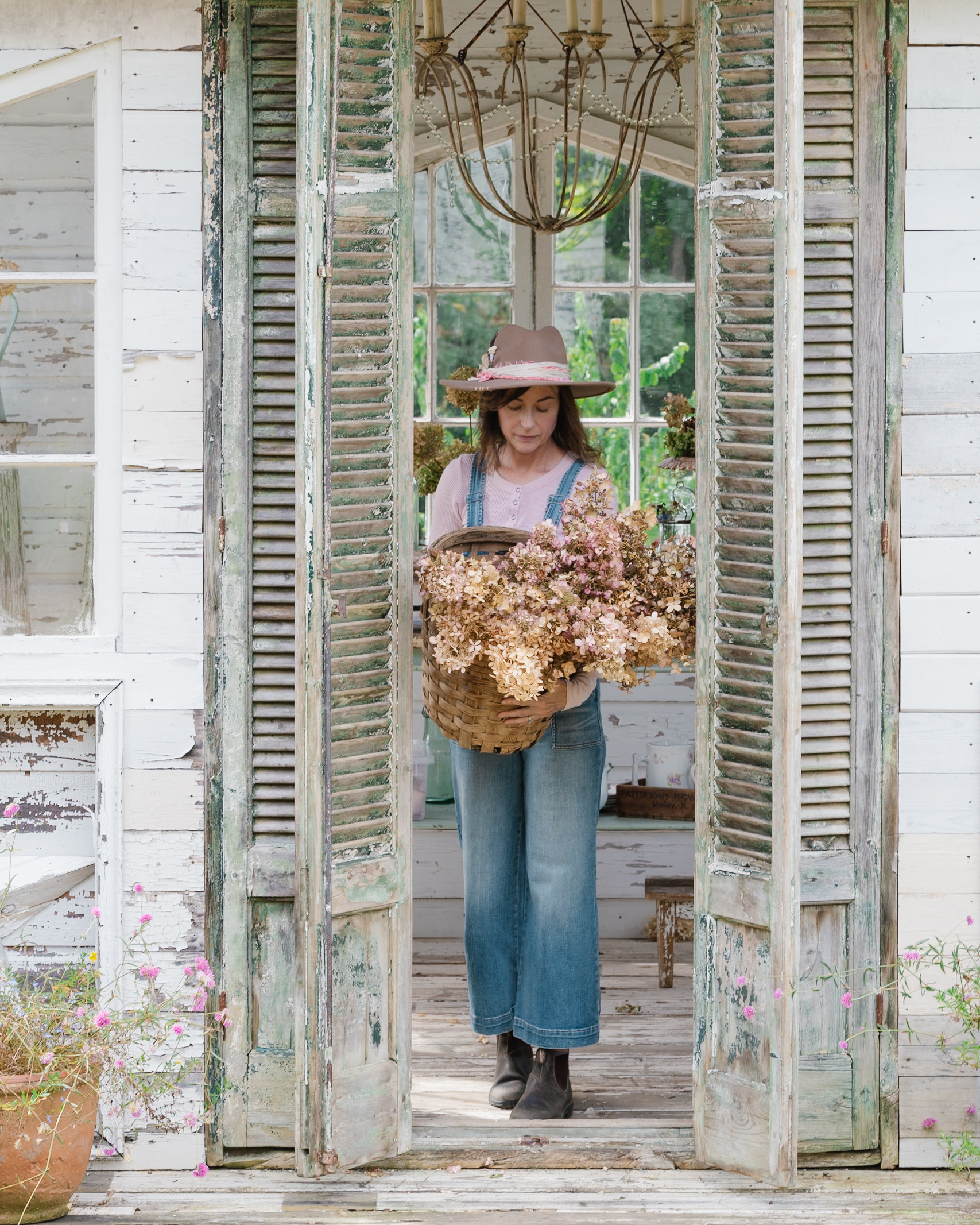 Jayne in the flower house with a vintage basket of dried hydrangeas