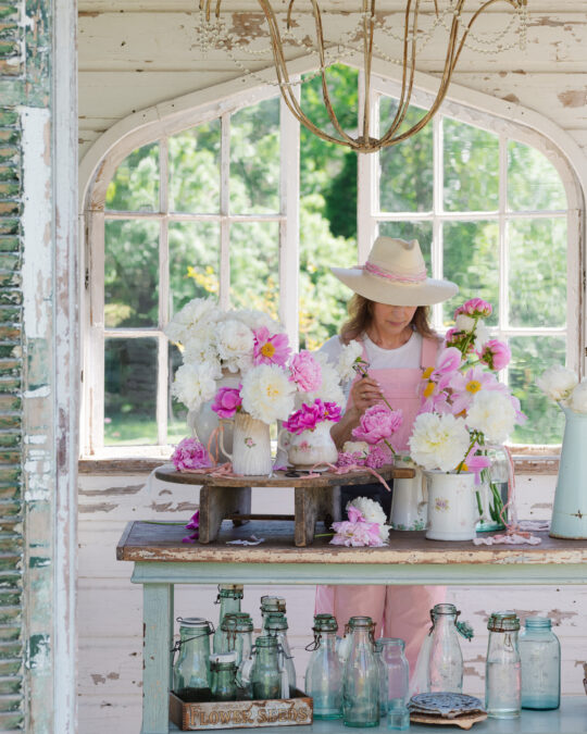Flower Gardener in the flower house with peonies